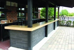 This precast outdoor bar countertop by Fishstone Studio was designed in five pieces to accommodate the shape and existing support poles.