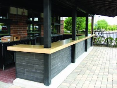 This precast outdoor bar countertop by Fishstone Studio was designed in five pieces to accommodate the shape and existing support poles.