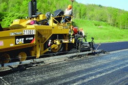 A 30-foot multi-articulated averaging ski is installed on the left side of the paver, with first pull truing and leveling over the rough PCC surface.