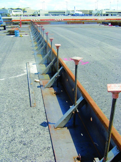 Metal forms are set in place at the Oakland International Airport prior to pouring one 40-foot-wide lane of an 18-inch-thick concrete apron. Forms were designed with a 4-1/2-inch extension that can be added to form a deeper perimeter.