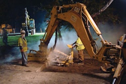 A backhoe mounted drill assembly is used to create holes for dowel bars.