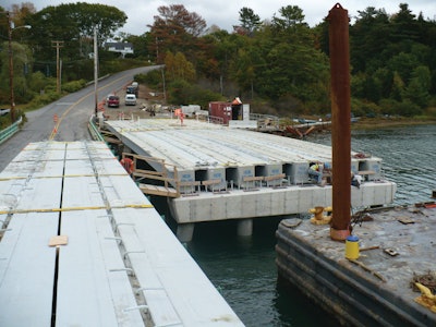 First two spans of the Knickerbocker Bridge set in place with the third span in foreground on truck ready to be placed. The crew is preparing bearing seats.