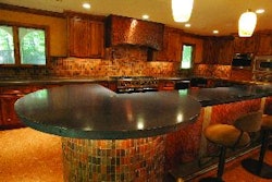 Concrete Connexion completed about 40 feet of precast countertops throughout a residential home. Jarman chose a subtle countertop look for a quiet balance with the client's rich-grained cabinet woodwork. The island and countertops are 2 inches thick with a 6 degree bevel on all the cantilevered leading edges.