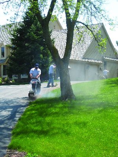 'As far as the maintenance, it all goes hand in hand,' says Jeff Schmitt, owner of Kettle Moraine Asphalt Maintenance. Before sealing the driveway, the crew edges, fills cracks, and blows away debris.