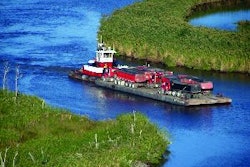 Initially, the client's tug and barge looked like the best way to transport hot mix to the island paving site. On closer examination, however, it was decided to rent a second barge to more efficiently carry twice as many trucks to the site at one time.