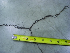 Unrestricted crack width growth leads to spalled edges along out-of-joint cracks when exposed to wheeled traffic, especially hard-wheeled lift trucks.