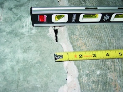 This out-of-joint floor crack was caused by excessive concrete shrinkage and joint spacing. Because of the wide crack width and curling, load transfer across this crack through aggregate interlock has been lost.