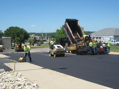 Another crew member followed the paver and the roller with a walk-behind compaction plate to ensure all edges along the sidewalk and parking lot were compacted properly.