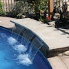 This concrete bench was precast and then placed over the waterfall to create this water feature.