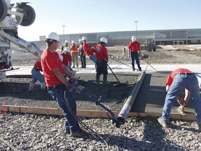 A pervious concrete pavement placement works like an assembly line, says Dale Fisher, with crew members working the ready-mixed truck's chute, members working the screed, and others following with finishing tools.