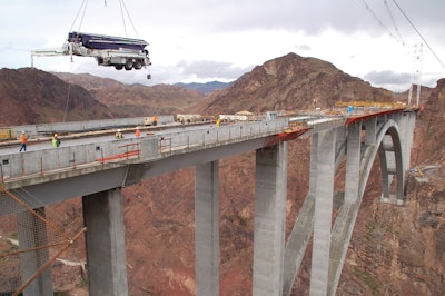 As crews begin the final stages of the historical Colorado River Bridge project, a Putzmeister 52Z-Meter truck-mounted concrete boom pump is flown over 900 feet above the Colorado River for concrete placement of the driving deck.