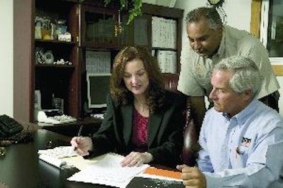 Lorie Waldrop, general manager, and Hikman Rahman, executive vice president, Terra Construction Group, go over a list of equipment destined for auction with Scott Linder, IronPlanet territory manager for Central Florida.