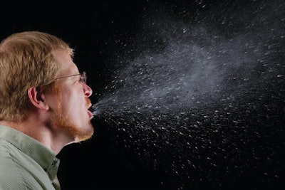 This photograph captured a sneeze in progress and illustrates the importance of covering your mouth when coughing or sneezing in order to protect others from germ exposure.