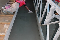 The sloped walls were too steep for Carolina Floors’ finishers to stand, so they lay on their stomachs to finish the velodrome grout wear surface using wooden hand floats. Finishing tolerances were very tight, less than 1/8-inch in 6 feet.