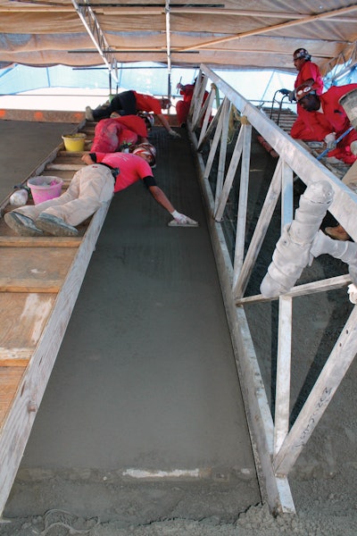 The sloped walls were too steep for Carolina Floors’ finishers to stand, so they lay on their stomachs to finish the velodrome grout wear surface using wooden hand floats. Finishing tolerances were very tight, less than 1/8-inch in 6 feet.