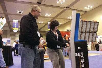 Michelle Cwach with The Road Connection (right), shows Greg Borquin of Upper Midwest Sealcoat Manufacturing how to send a letter to Congress from the kiosk.