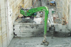 The operator of the SENNEBOGEN 870 M scoops up tailings with a custom clamshell bucket.