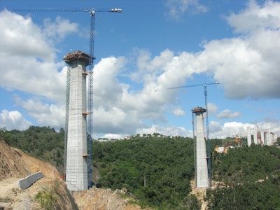 Pillars number 18 and 19, the highest of the whole structure, are being built by two Linden Comansa Flat-Top tower cranes, model 21 LC 400, with maximum load capacity of 39,680 lbs. and erected with jib lengths of 229 ft., allowing them to load up to 11,020 lbs. at the jib-end.