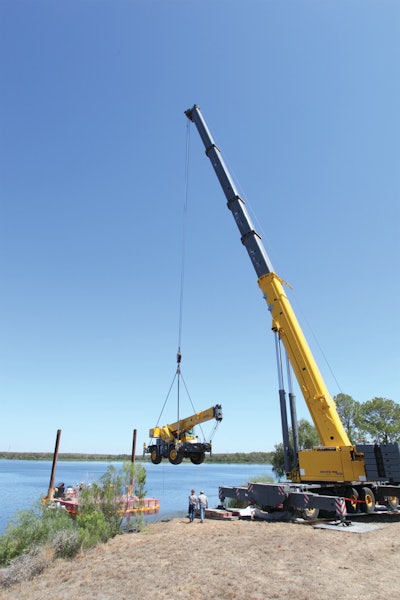 The 550-USt GMK7550 lifted a Grove RT530E-2 rough-terrain crane onto a barge to replace stop logs on the dam.