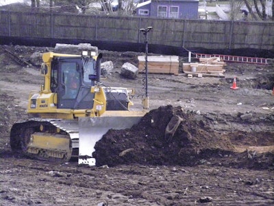 Komatsu dozer equipped with twin antenna Topcon 3D-MC2 automated grade control system levels out a steep slope.