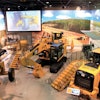 An overview of an equipment display at the Caterpillar Visitors Center, where deep exposed aggregate polished concrete floors were designed to emulate a gravel pit or construction site.