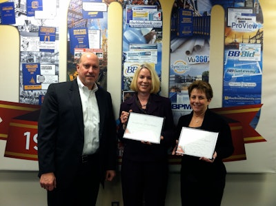 Rich Johnson, The Blue Book president, presents a symbolic 'Certificate of Ownership' to two of the company's most tenured employees: (L to R) Meg Hillmann, manager of paid order processing, and 30+ year veteran and Mary Ann Crisci, supervisor of customer service.