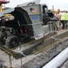 The mid-size curb and gutter machine pours close to the 90-degree transition point.
