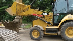 Dumping buckets of stone into an excavator bucket of a Cat 345.