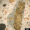 Figure 1. Stereomicroscope image. Reflected light photomicrograph of the polished surface of a concrete core. The image was taken at 10x magnification. The red arrows highlight mortar with darker color than surrounding concrete matrix. Features such as these often form when concrete is retempered.