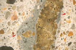 Figure 1. Stereomicroscope image. Reflected light photomicrograph of the polished surface of a concrete core. The image was taken at 10x magnification. The red arrows highlight mortar with darker color than surrounding concrete matrix. Features such as these often form when concrete is retempered.
