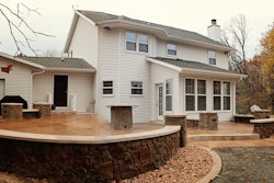 This central Wisconsin backyard patio incorporates several decorative concrete applications, from textured and stamped slabs to vertical carved pillars to a precast fire table top.