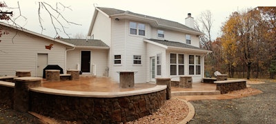 This central Wisconsin backyard patio incorporates several decorative concrete applications, from textured and stamped slabs to vertical carved pillars to a precast fire table top.