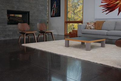 Black polished concrete floors and a two-story, board-formed, cast-in-place concrete fireplace offer raw texture in this modern home.