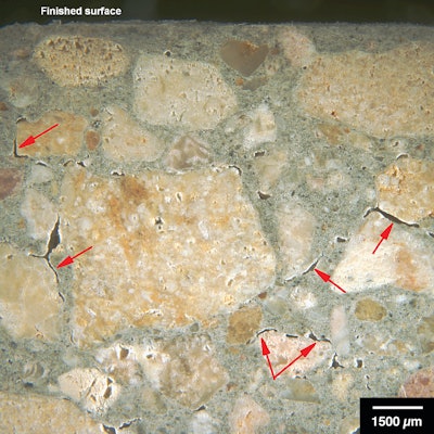 Figure 2: Reflected light photomicrograph of polished surface showing adhesion microcracks (red arrows) near the top of a slab.