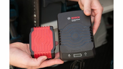 Bosch’s new induction charging system for tool batteries includes a charging pad (right) and a battery (left) that includes a coil of wire located just under the red plastic bottom of the battery. No mechanical connection required.