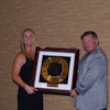 Mitzi McIntyre, Executive Director of the Utah Chapter of the American Concrete Pavement Association (ACPA), receives the 2014 Concrete Pavement Restoration (CPR) Promoter of the Year Award from John Roberts, Executive Director of the IGGA.