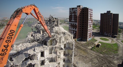 Contractor Homrich utilized its Hitachi 800 Ultra High Reach, in combination with an old-fashioned wrecking ball hung from a 200-ton truck crane to safely demolish four 15-story high-rise buildings.
