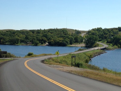 Knife River Materials, Bemidji, MN, for work on Barnes County Highway 21, just north of Valley City, ND. The roughly 11.5-mile full-depth mill-and-overlay project used more than 20,000 tons of asphalt. The scope of the project included about 30 asphalt patches, .75-inch milling, and then two inches of reclaimed asphalt pavement surface on top.
