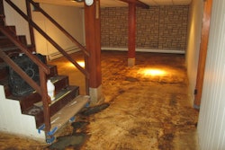 Picture here is a substrate that was scrubbed with a silicon carbide impregnated nylon grit brush and given two coats of micro-topping to restore the floor. Once the water-based dye was applied, the old details of the vinyl tiles appeared.