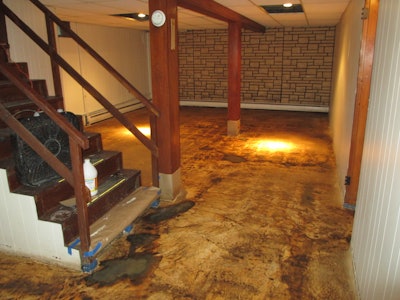 Picture here is a substrate that was scrubbed with a silicon carbide impregnated nylon grit brush and given two coats of micro-topping to restore the floor. Once the water-based dye was applied, the old details of the vinyl tiles appeared.