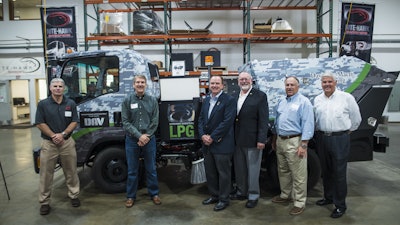 In front of the NiteHawk's camouflage sweeper (which raised $1500 for DAV) are (from left) Tracy Day, President, NiteHawk Sweepers; Bob Anderson, President, Davidson-Macri Sweeping; Robert Lougee, DAV; Bill Centers, U.S. Navy Rear Admiral, retired; Ron Robinson, CEO and President, Alamo Group; Jeff Leonard, Vice President, Alamo Group. The new NiteHawk facility is located at 19713 58th Place S., Kent, WA.