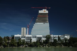 The WOLFF 7532.16 and the WOLFF 180B luffing crane (left) at Roche Building 1. Due to the unusual shape of the building, the 180 B replaced a WOLFF 6023.8 after a certain height.