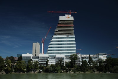 The WOLFF 7532.16 and the WOLFF 180B luffing crane (left) at Roche Building 1. Due to the unusual shape of the building, the 180 B replaced a WOLFF 6023.8 after a certain height.