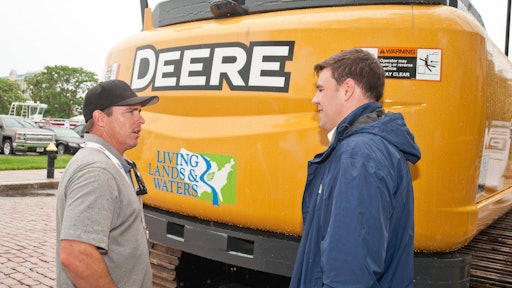 Chad Pregracke, left, of Living Lands & Waters and his new excavator, which will be put to work cleaning up the Ohio River.