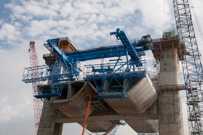 The new St. Croix River crossing between Minnesota and Wisconsin near Stillwater is an “extra-dosed precast segmental” structural concrete bridge. Shown here are the first three 180 ton segments on either side of the pier, held in place by post-tensioned tendons. The blue device is called a “segment lifter” and it also supports a working platform on the edge of the segment that iron-workers use to do the cable tensioning.