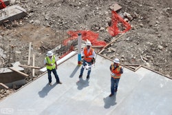 Workers launch an unmanned aerial vehicle (UAV) to take progress photos on a Rogers-O'Brien Construction site.