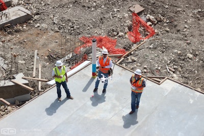 Workers launch an unmanned aerial vehicle (UAV) to take progress photos on a Rogers-O'Brien Construction site.