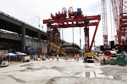 Crews worked Monday, Aug. 24, 2015 to begin one of four crane operations to lower Bertha's cutter head and drive unit back into the ground. Once the giant tunnel boring machine is back together and tested, it will start tunneling again Nov. 23, nearly two years after it stopped 1,000 feet into the nearly two-mile tunnel project. This wide shot shows the giant 'super crane' used to first pull the 4-million-pound cutter head out of the ground and now to lower it back in.