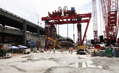 Crews worked Monday, Aug. 24, 2015 to begin one of four crane operations to lower Bertha's cutter head and drive unit back into the ground. Once the giant tunnel boring machine is back together and tested, it will start tunneling again Nov. 23, nearly two years after it stopped 1,000 feet into the nearly two-mile tunnel project. This wide shot shows the giant 'super crane' used to first pull the 4-million-pound cutter head out of the ground and now to lower it back in.