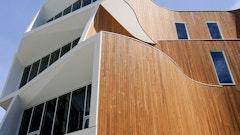 The building features distinct curves and apertures that make it standout visually as well as allow sunlight and shade to be optimized for the lighting and temperature, saving energy and enhancing comfort levels for occupants.